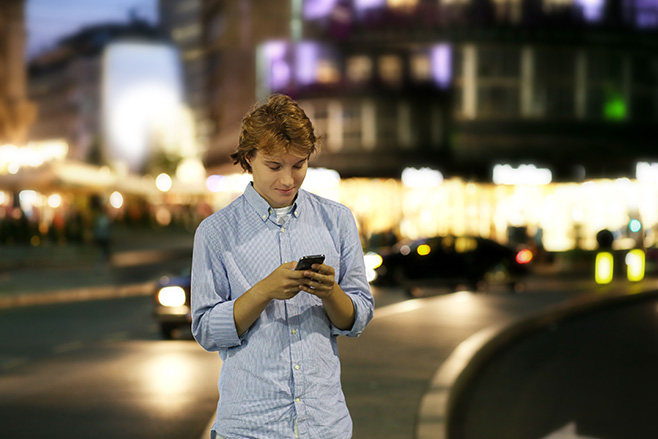 Man texting crossing the road