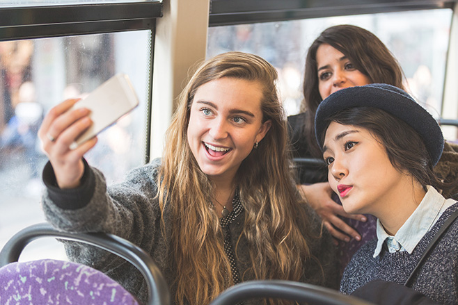 Young people on bus taking photo