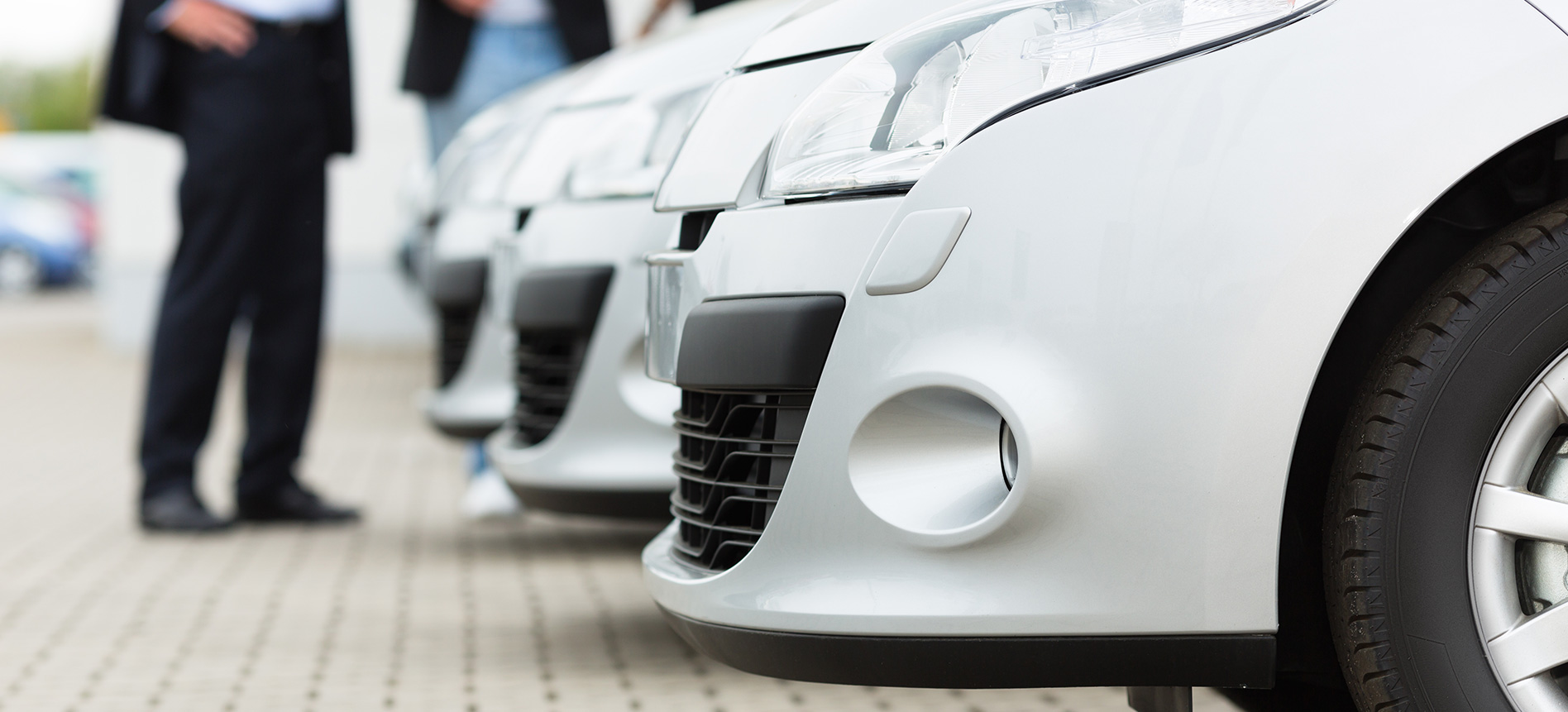 Car dealer and new car buyers at dealership