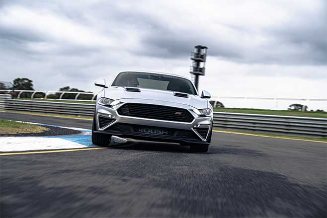 Supercharged Ford Mustang cornering on track.