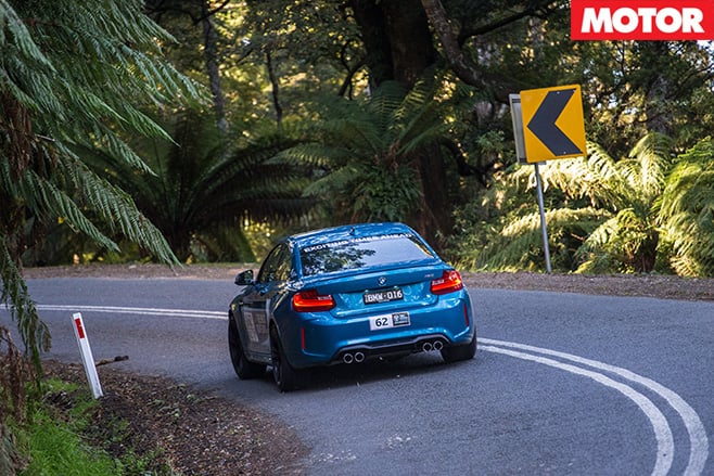 BMW M2 driving through forest