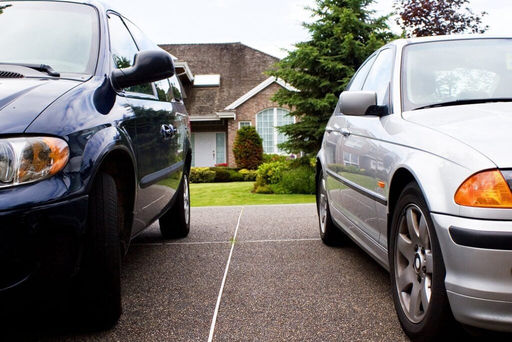 cars parked outside of suburban house