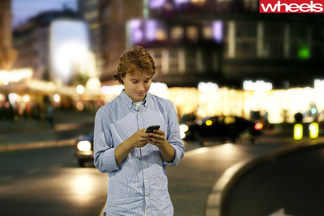 Young -man -texting -on -side -of -road