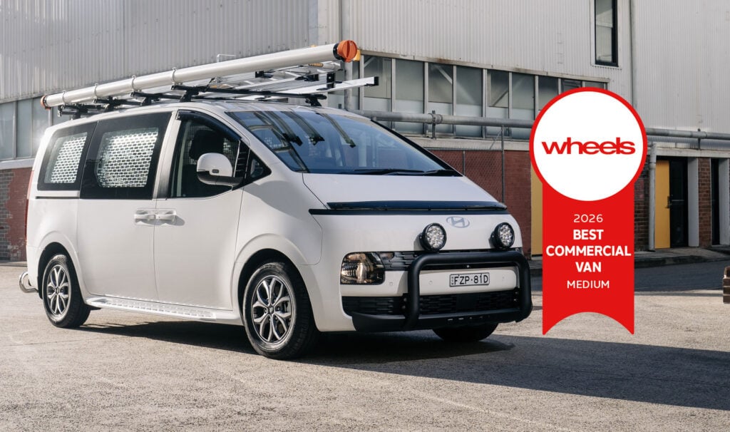 White commercial van with a roof rack and ladder, beside a red Wheels award ribbon reading '2026 Best Commercial Van Medium'.