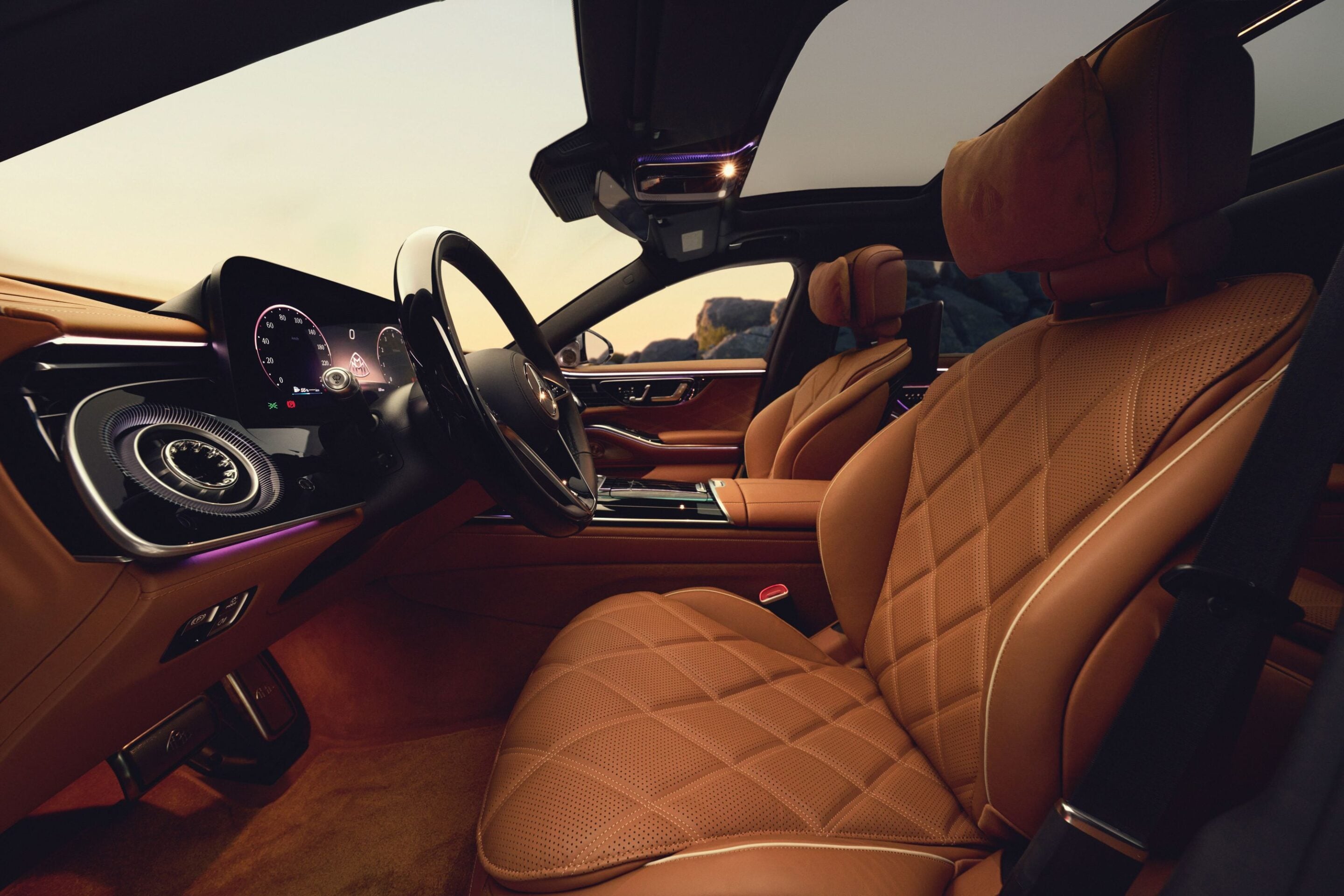 Luxury car interior with tan perforated leather seats, sleek dashboard, and steering wheel viewed from the passenger side, sunlit cabin interior