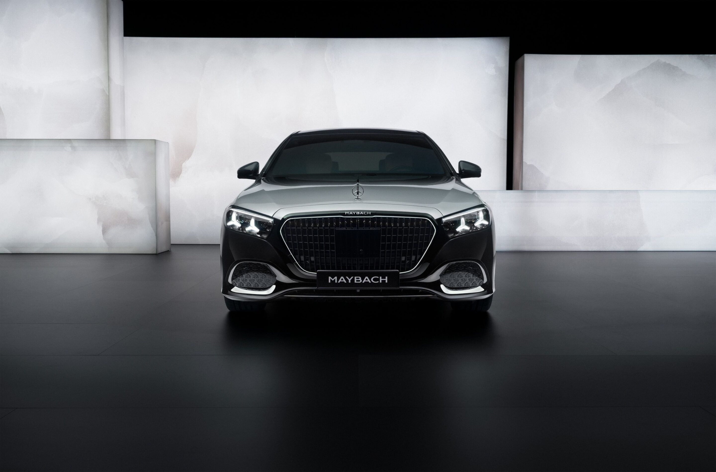 Front view of a silver Maybach luxury sedan in a white minimalist showroom.