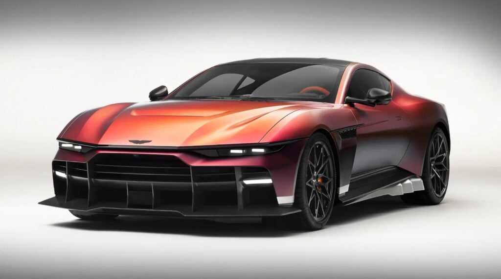 Red low-profile sports car with a black roof, prominent front splitter, and large dark wheels in a studio setting.