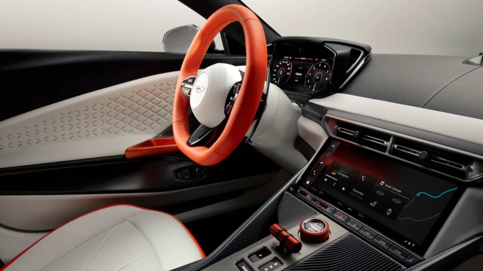 Luxurious car interior featuring an orange steering wheel, white seats, and a digital instrument cluster with a center console touchscreen nearby