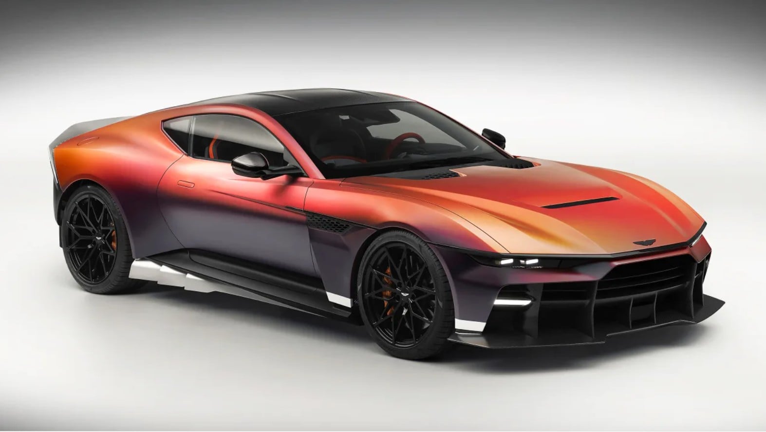 Orange-to-purple gradient sports car with black roof and large black alloy wheels, viewed from front-left.