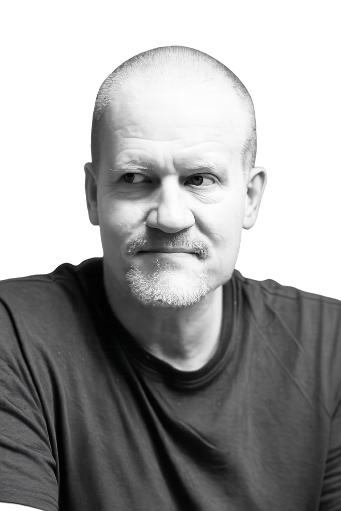 Black-and-white portrait of a middle-aged man with short hair and light beard, looking to the left.