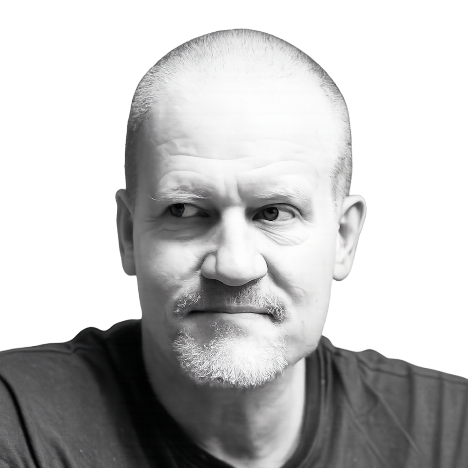 Black-and-white portrait of a middle-aged man with short hair and light beard, looking to the left.