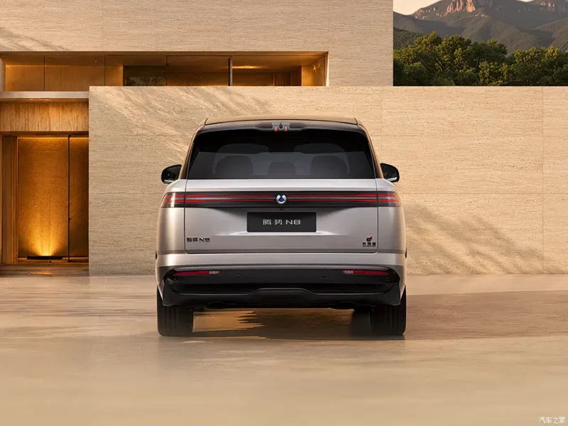 Rear view of a silver BMW SUV parked in front of a beige modern building
