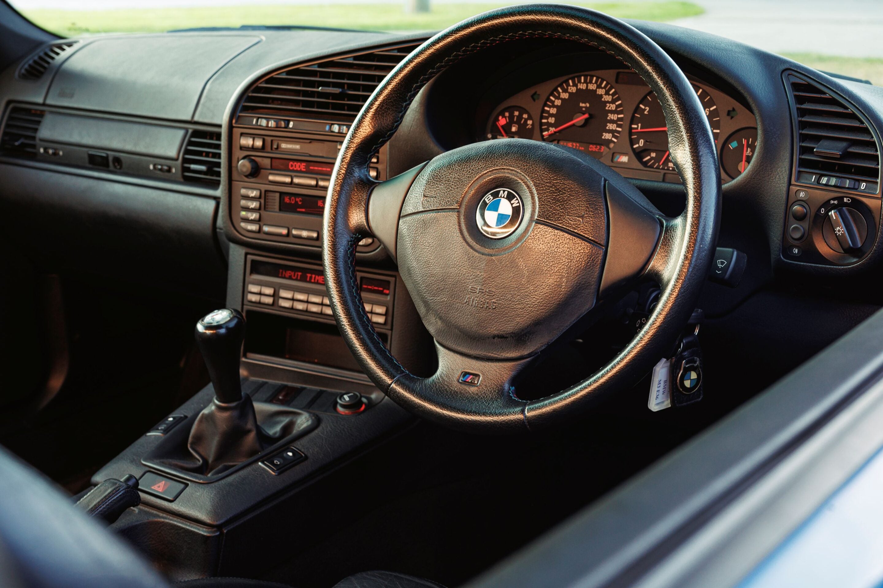 BMW car interior: close-up of steering wheel with instrument cluster and center console visible