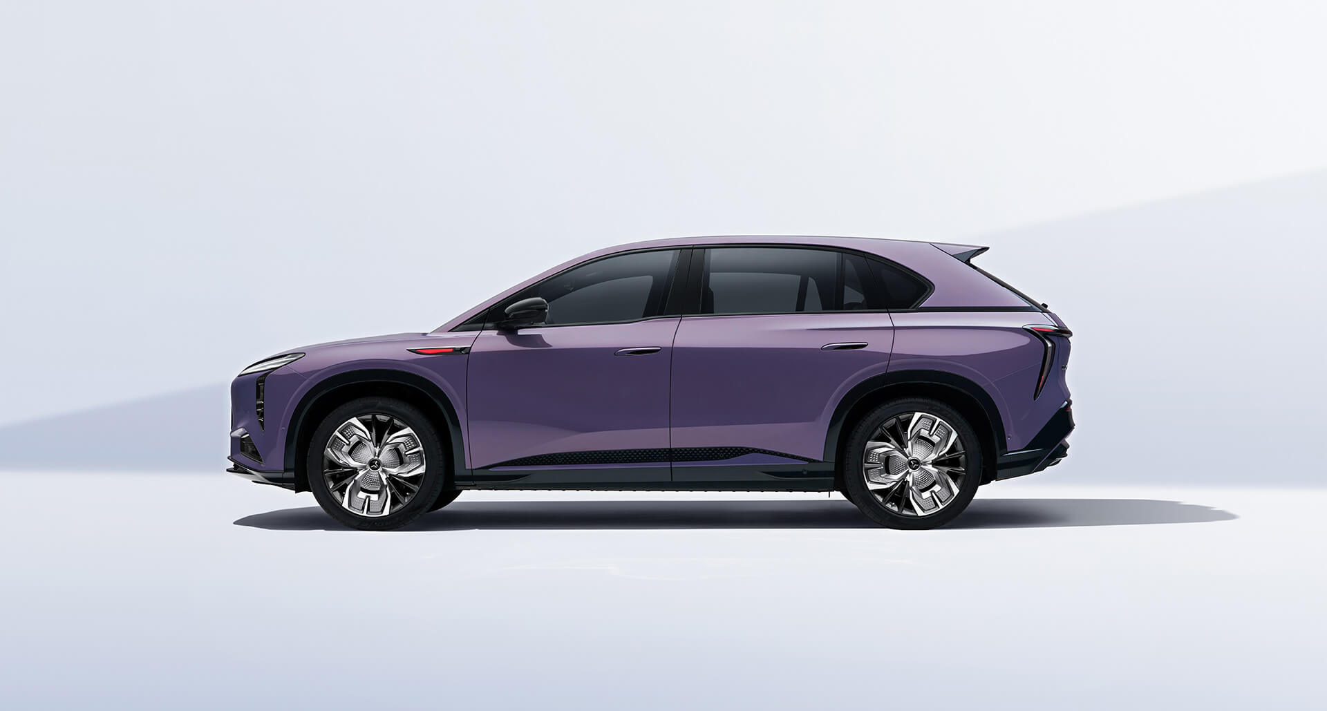 Side view of a purple SUV with large alloy wheels on a light gray background.
