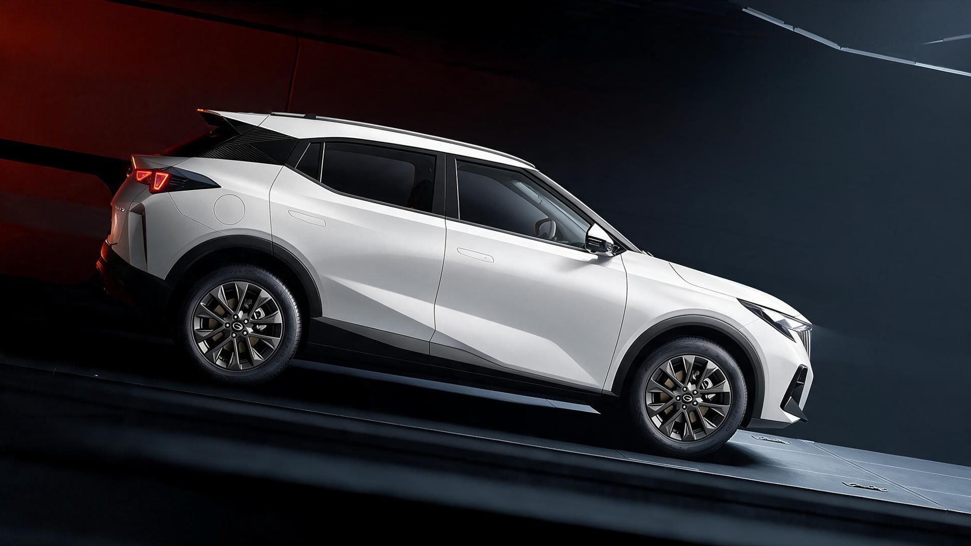 White SUV shown in a studio setting, angled side profile highlighting sleek lines and large alloy wheels.