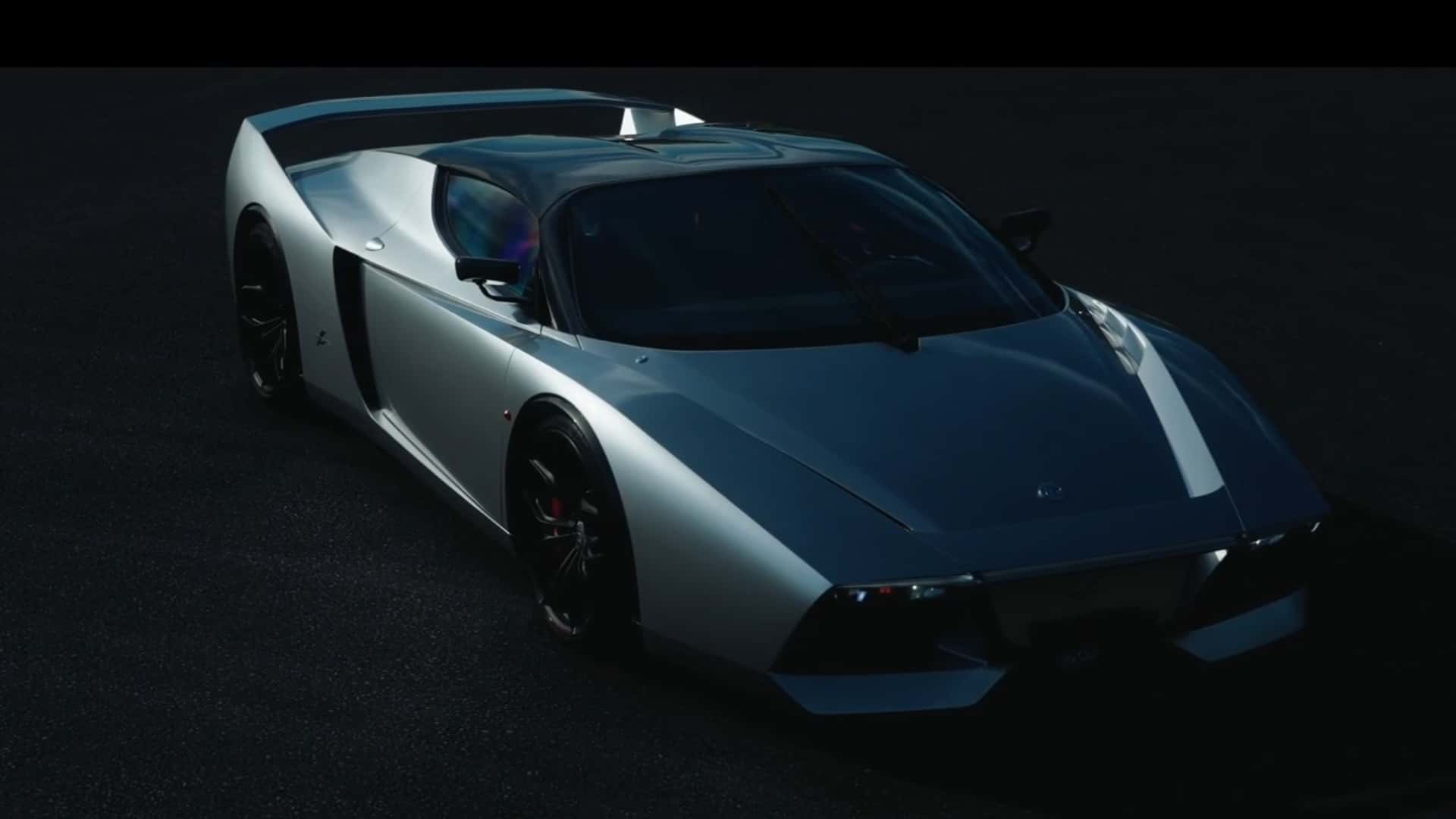 Top-down view of a silver and blue sports car on a dark surface, highlighting its aerodynamic body and rear spoiler.