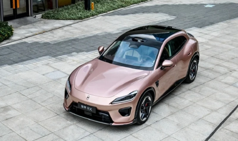 Rose-gold sports car (Porsche) in a three-quarter front view parked on a light stone plaza.