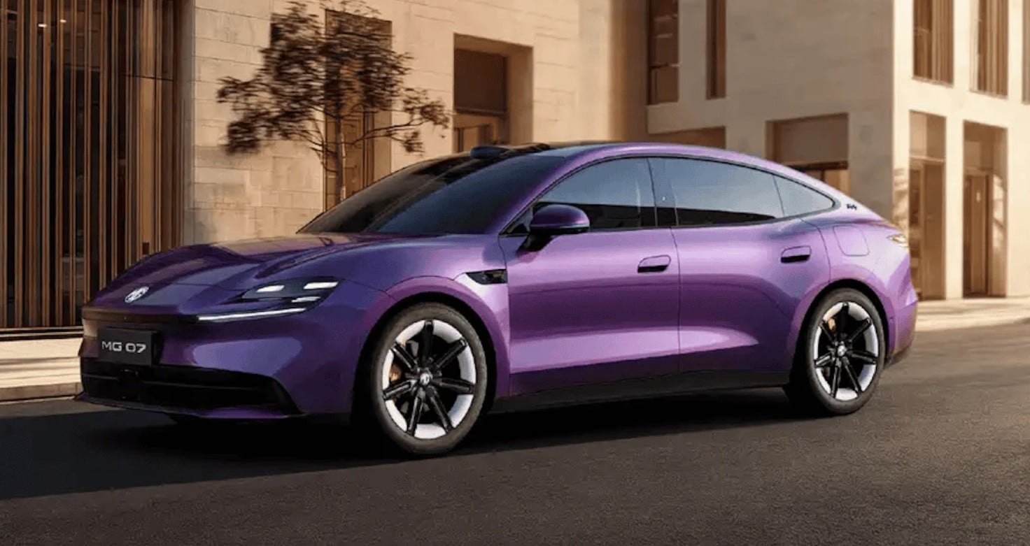 Purple MG O7 electric sedan parked on an urban street beside modern buildings.