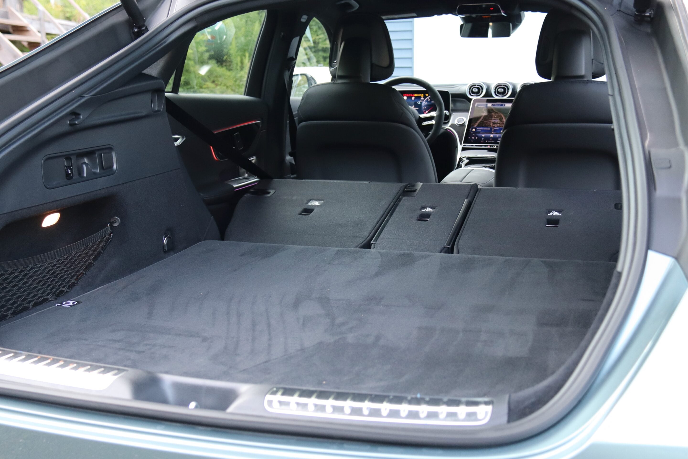 Open SUV hatch revealing a large flat cargo area with rear seats folded down, view toward front seats and dashboard.