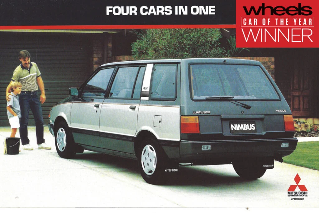 Rear three-quarter view of a silver Mitsubishi Nimbus station wagon on a driveway; a man and child wash it nearby in a sunny suburban scene.