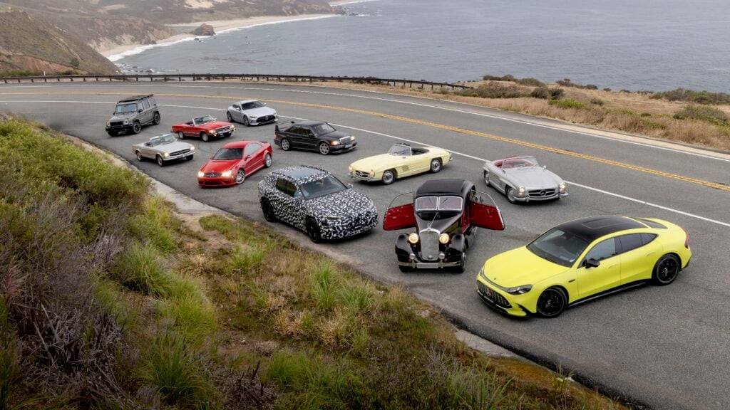 lineup of luxury cars parked along a winding coastal highway with cliffs and the ocean in the background.