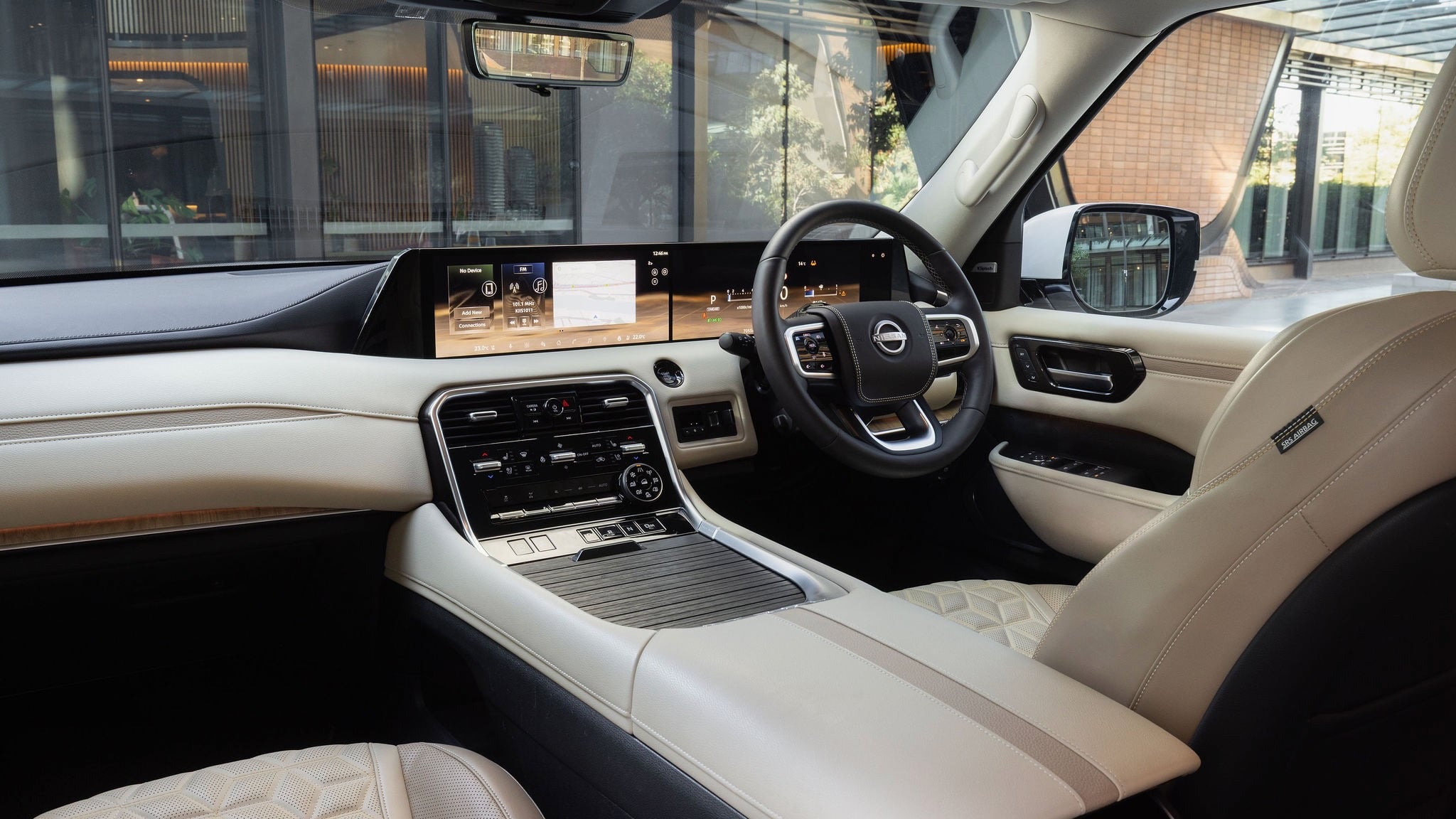 Luxurious car interior with beige leather seats, large digital dashboard, and steering wheel view from the passenger side.