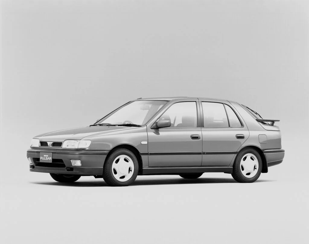 Gray four-door sedan with a small rear spoiler, shown in profile side view, wheels with hubcaps and a Pulsar badge on the front plate indicating the model.
