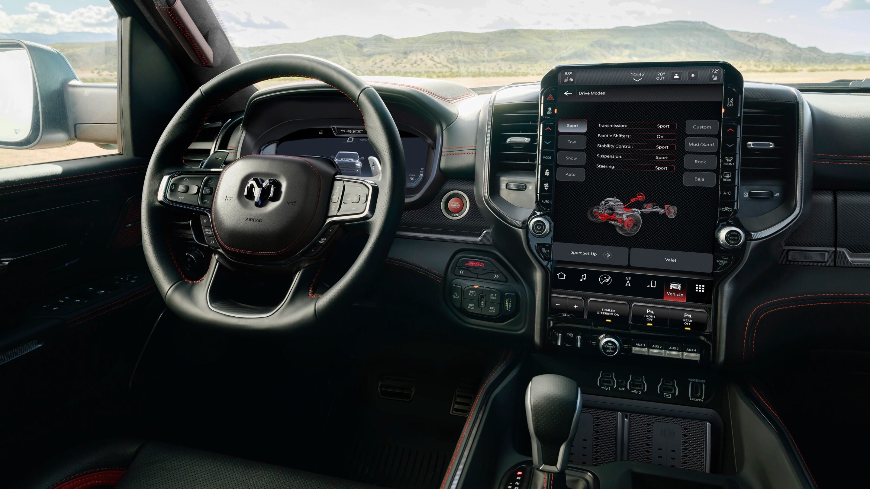 Car cockpit with a large vertical touchscreen infotainment panel on the center console, a leather-wrapped steering wheel with red stitching, and desert scenery through the windshield.