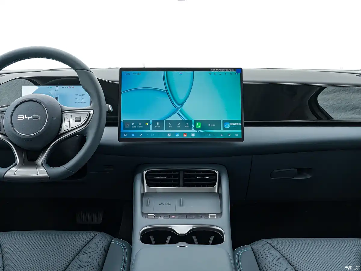 Modern car interior with a large central touchscreen and steering wheel on the left side, showpiece dashboard and controls.