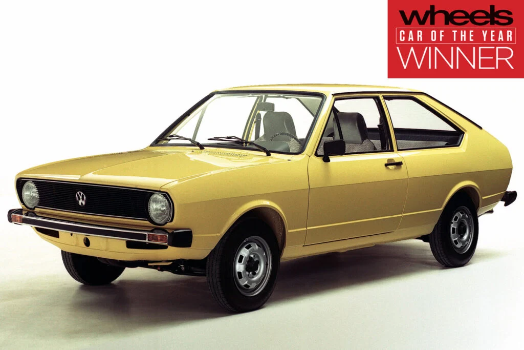Yellow vintage Volkswagen two-door coupe on a white studio backdrop with a Wheels 'Car of the Year' winner badge in the top-right corner.
