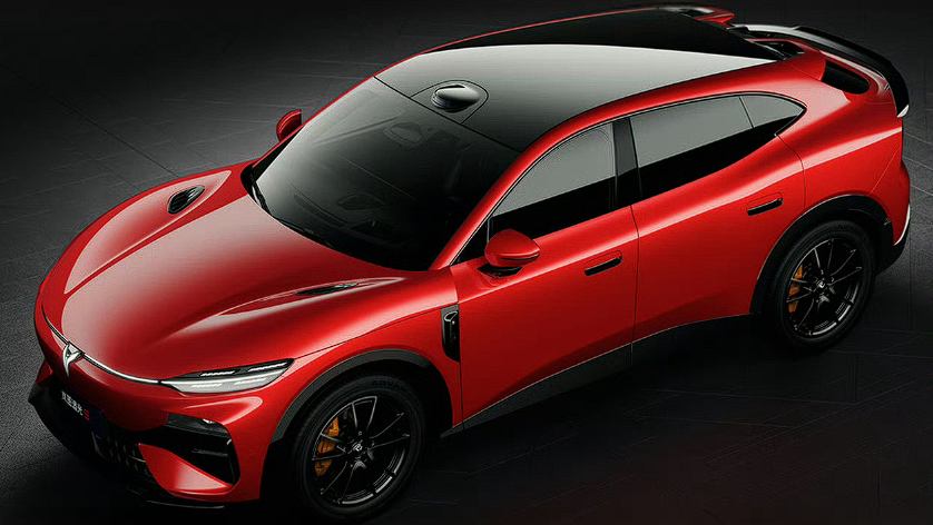 Top-down view of a red high-performance car with a black roof and sleek styling on a dark surface, showcasing its curves and stance.