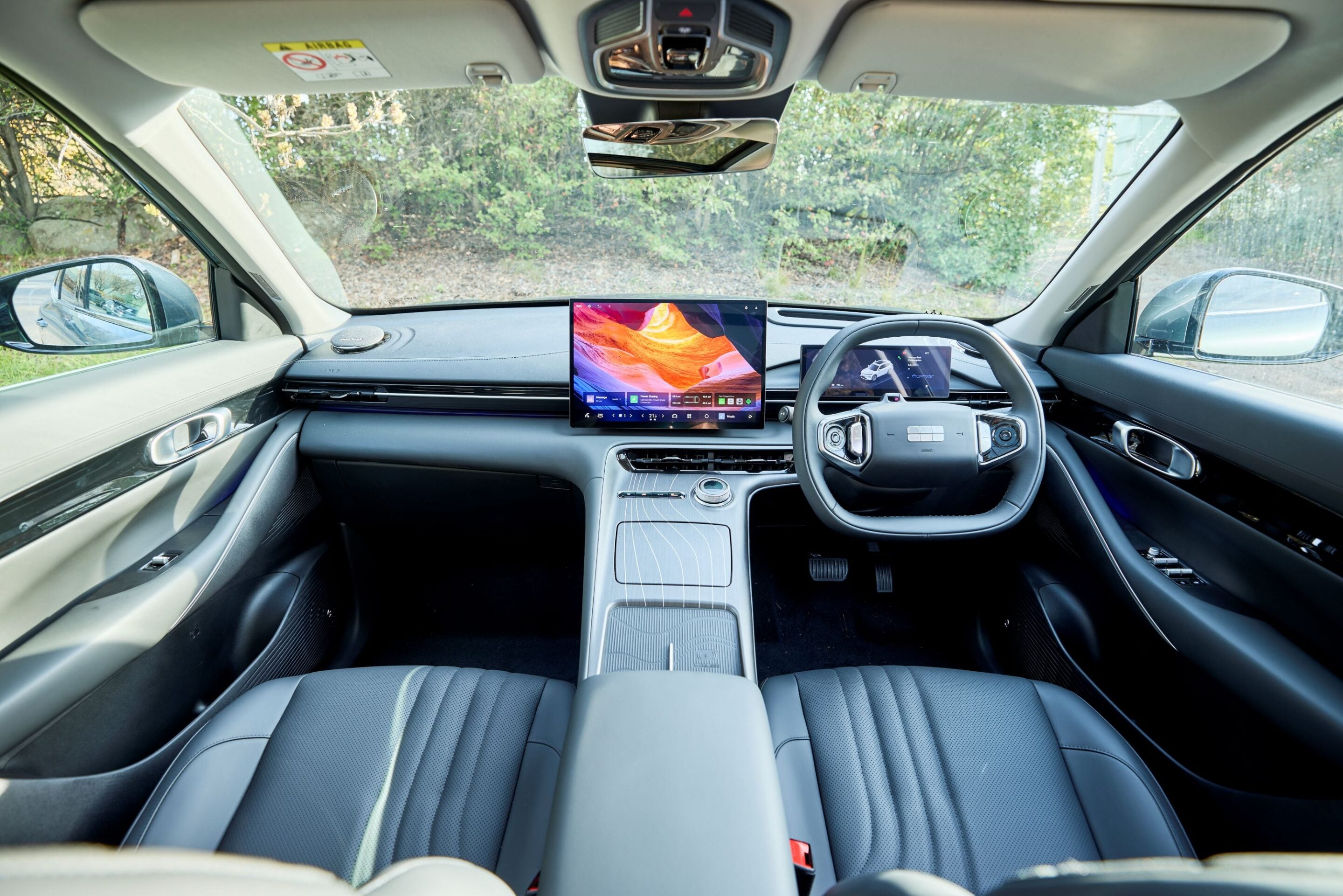 Modern car interior featuring a large portrait-style center touchscreen and a digital dashboard.