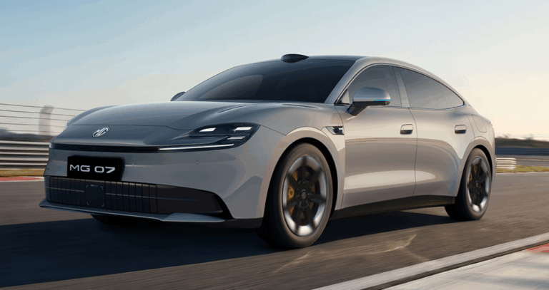 Sleek gray MG sedan speeding on a race track with a blurred background at sunset