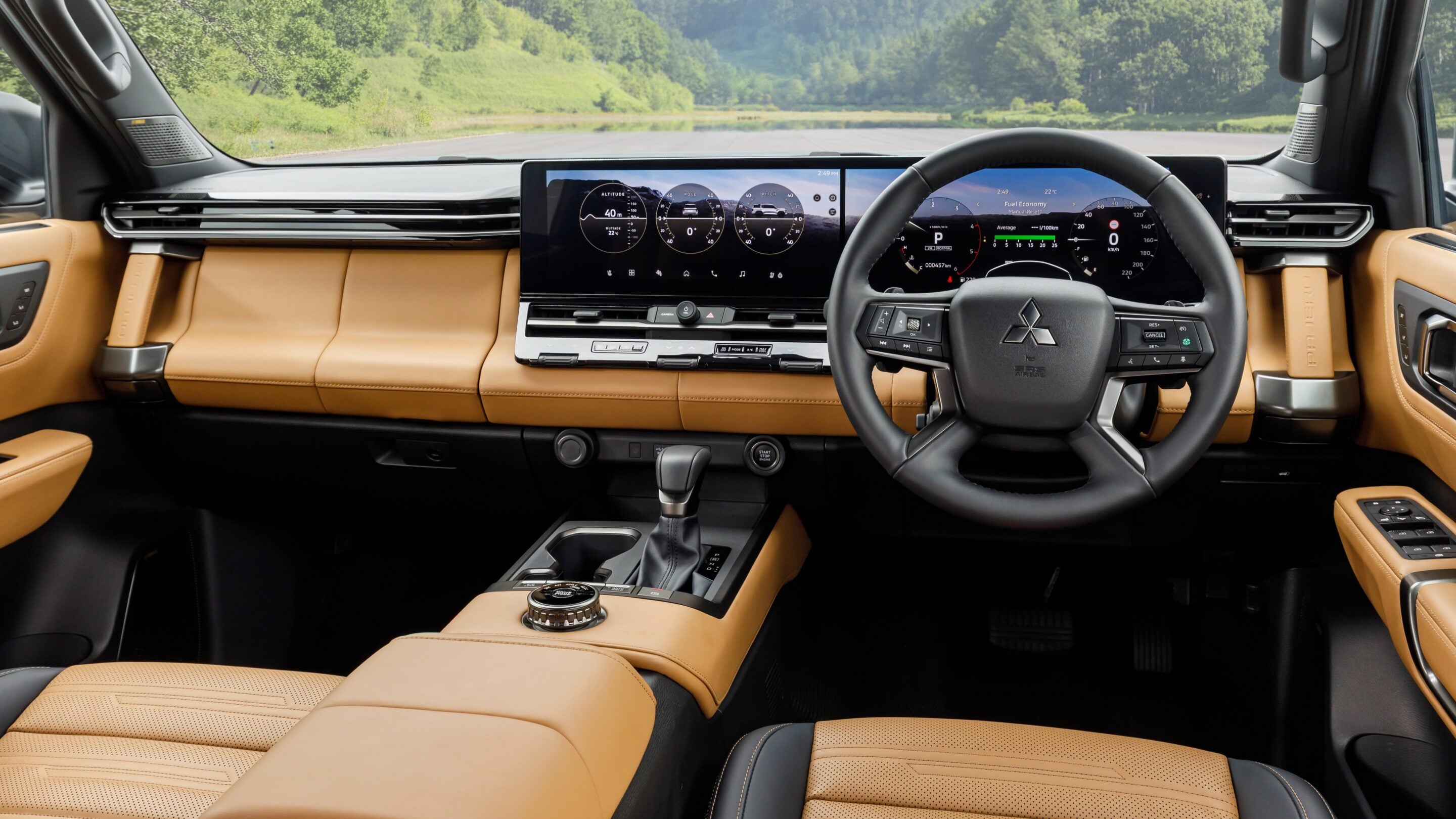 Interior of a car with tan leather seats, a wide digital dashboard, and a steering wheel.