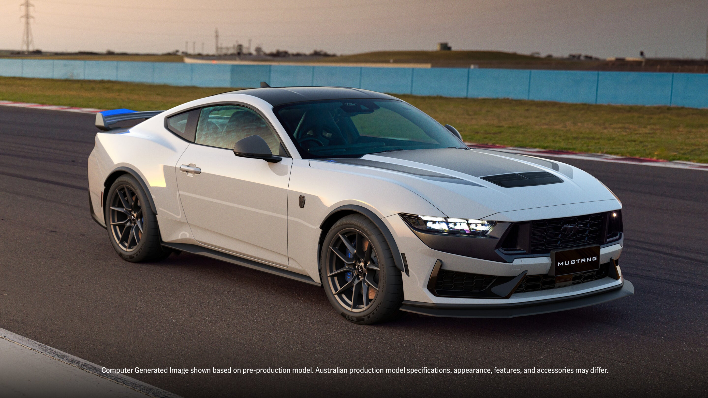 White Ford Mustang on a racetrack, three-quarter front view with a blue barrier in the background.