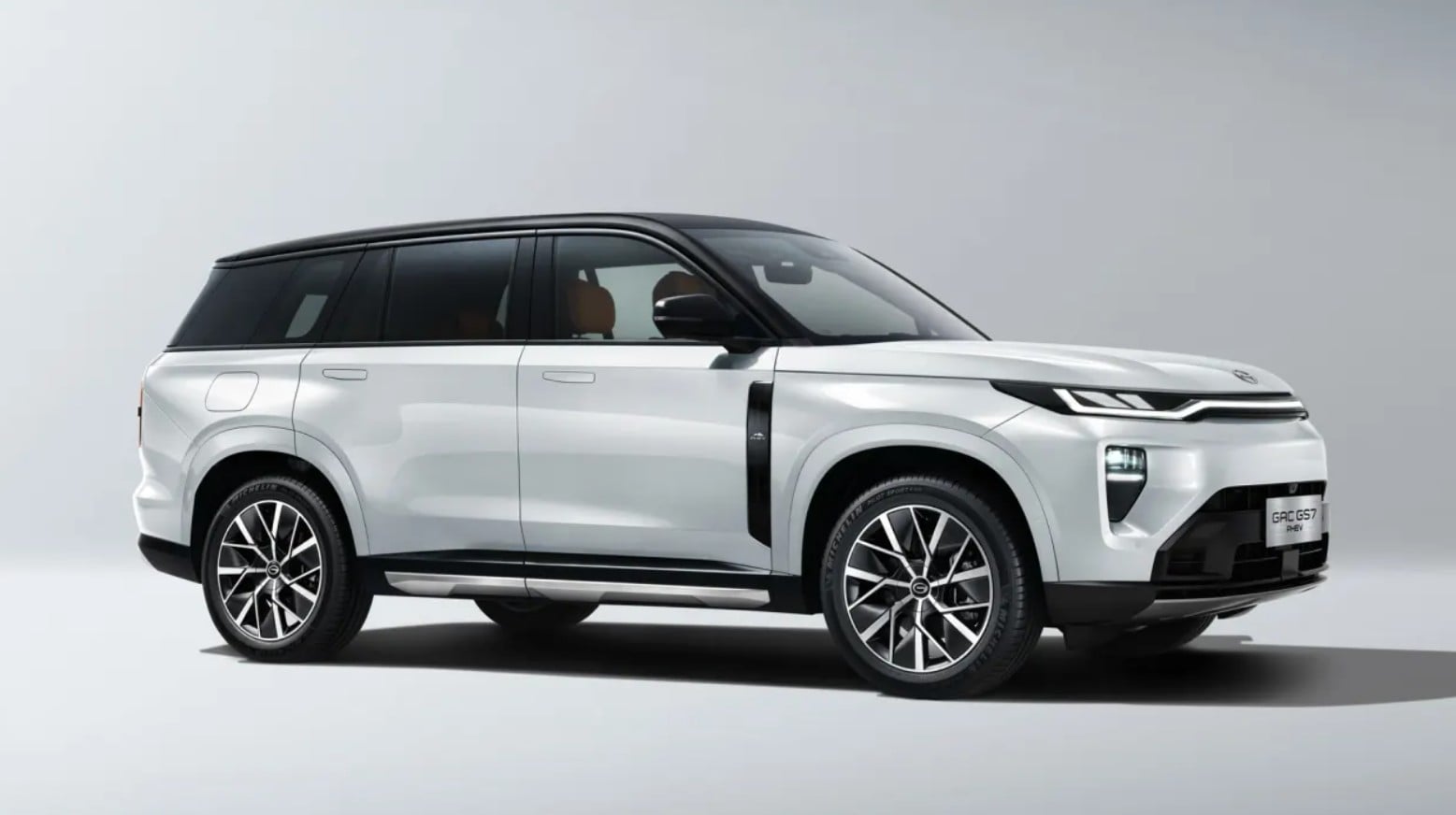 White SUV shown in a left-side profile with a black roof and large alloy wheels, parked on a plain background.