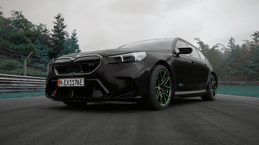Low-angle view of a black BMW M sport sedan with bright green-rimmed wheels on a race track, cloudy sky in the background