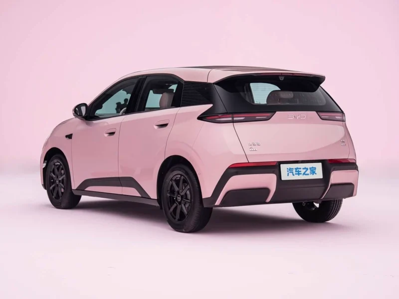 Rear three-quarter view of a pink compact SUV with black roof in a studio setting