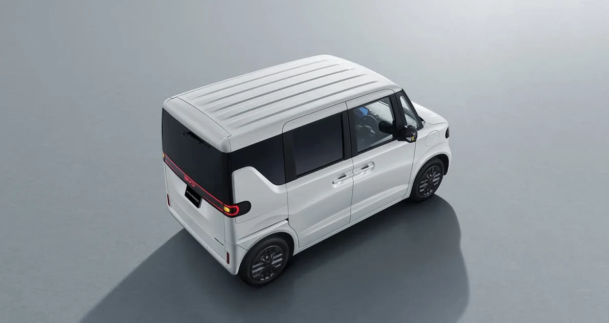 White compact van shown from a high rear-left angle on a gray studio floor surface.