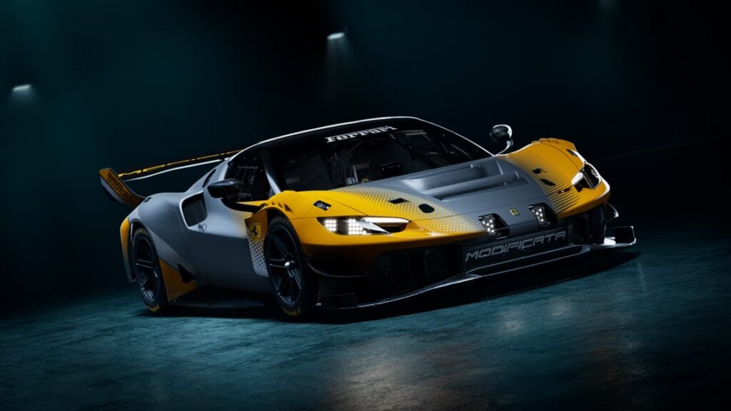 Ferrari race car in yellow and gray on a dark studio floor, front angled toward the camera.