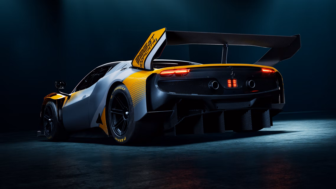 Rear view of a high‑performance race car in a dark studio, featuring a large rear wing, carbon fiber body, and red taillights with yellow accents.