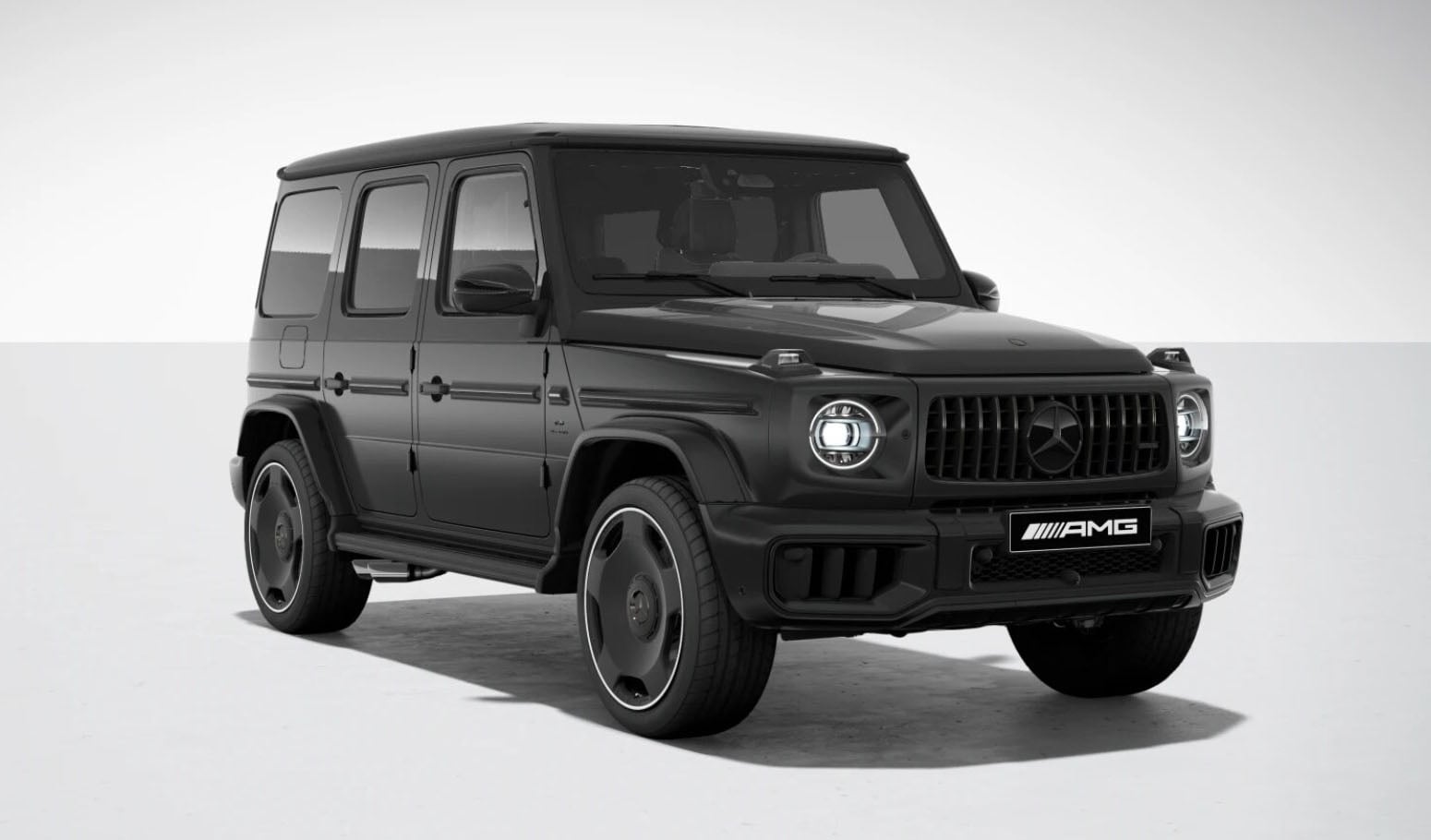 Front-left three-quarter view of a black Mercedes-Benz AMG G-Class SUV in a studio setting, showcasing its iconic grille and round headlights.