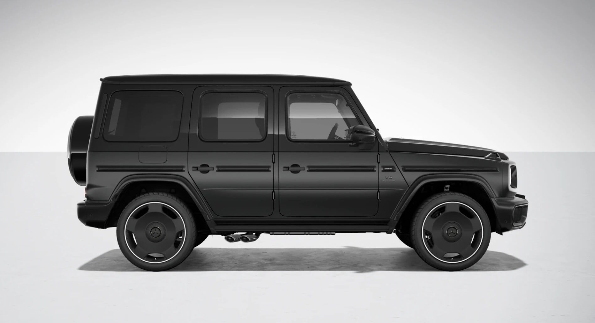 Side profile of a black Mercedes-Benz G-Class SUV facing left, indoors on a light floor and gradient backdrop.
