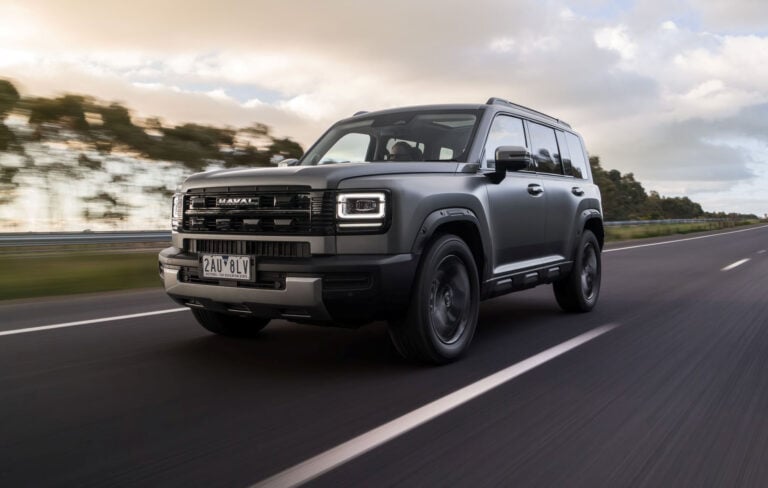 Gray Haval SUV driving at speed on a highway with blurred scenery in the background, front-left angle visible in motion