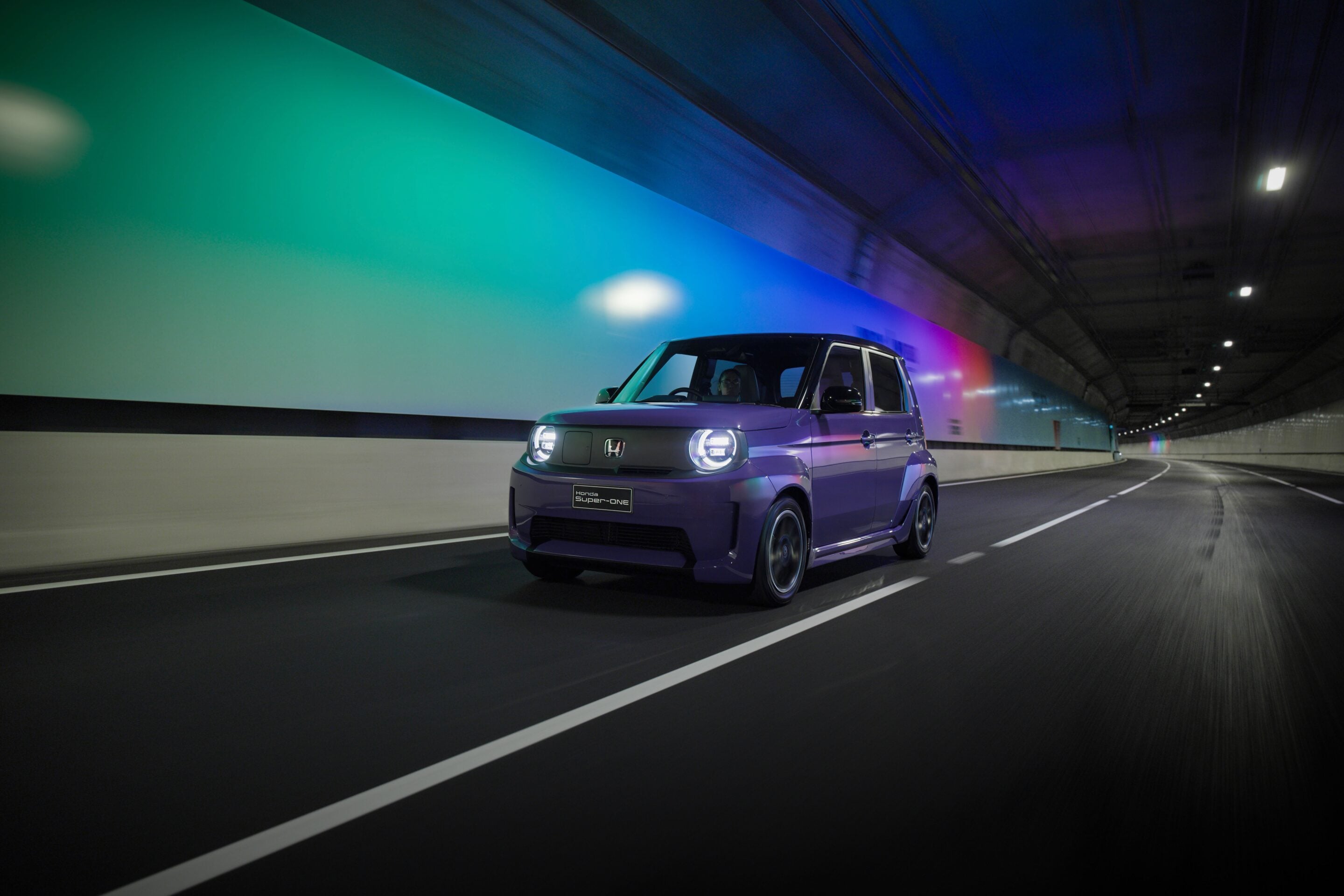 Purple Honda compact car driving through a tunnel with neon green, blue, and purple wall lights.