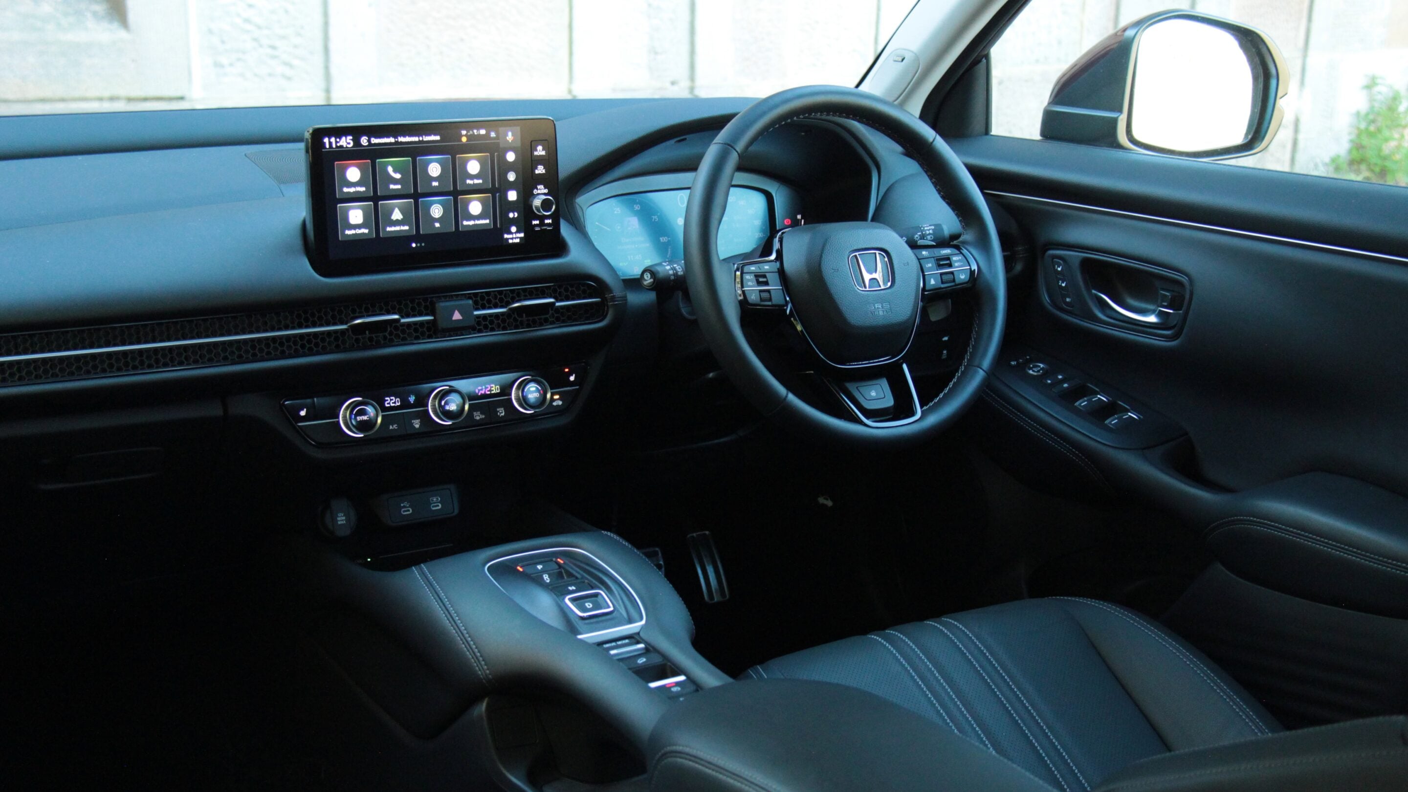 Interior of a car showing the dashboard, center touchscreen, climate controls, and steering wheel.