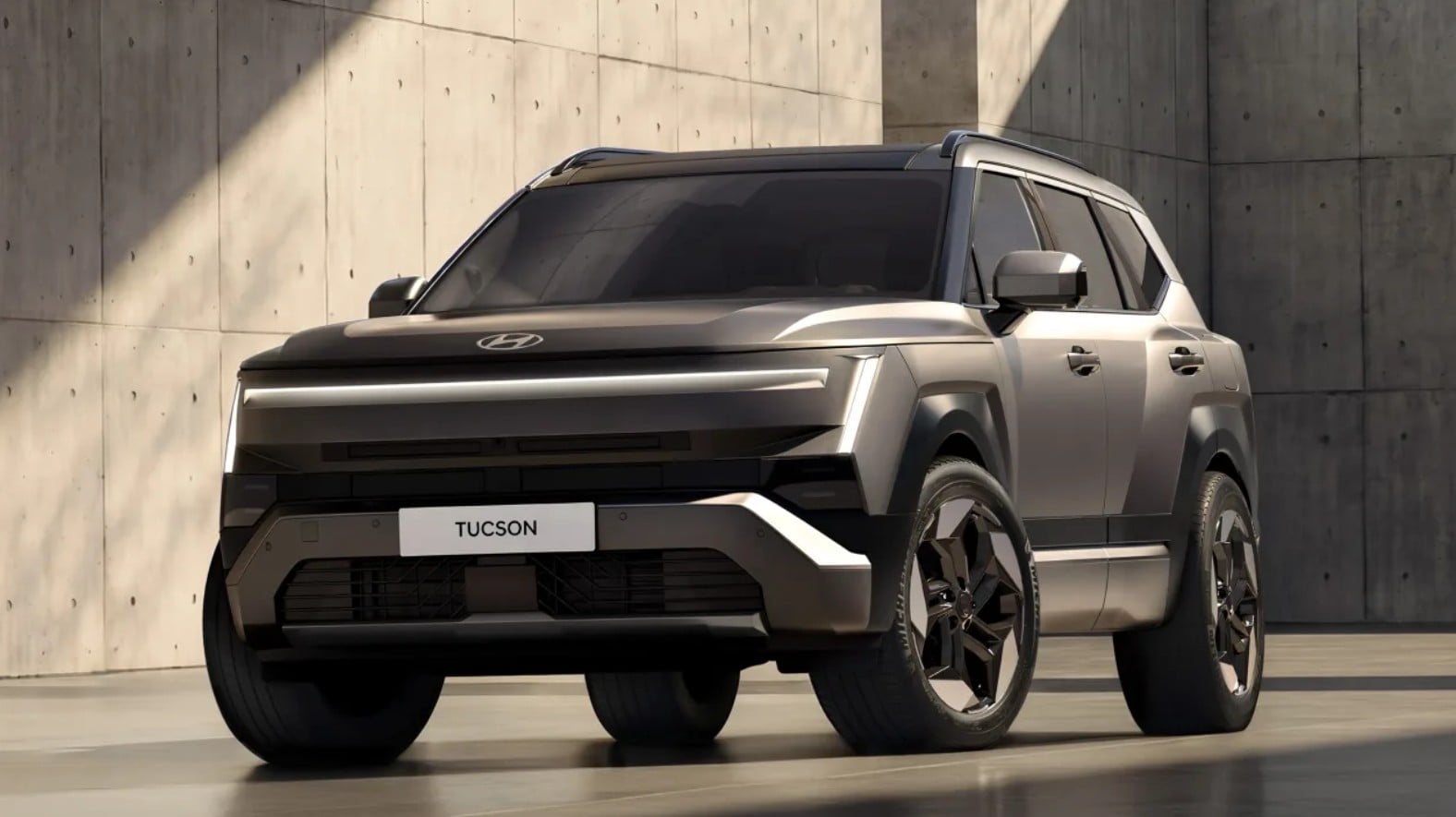 Front three-quarter view of a silver Hyundai Tucson SUV in a concrete setting.