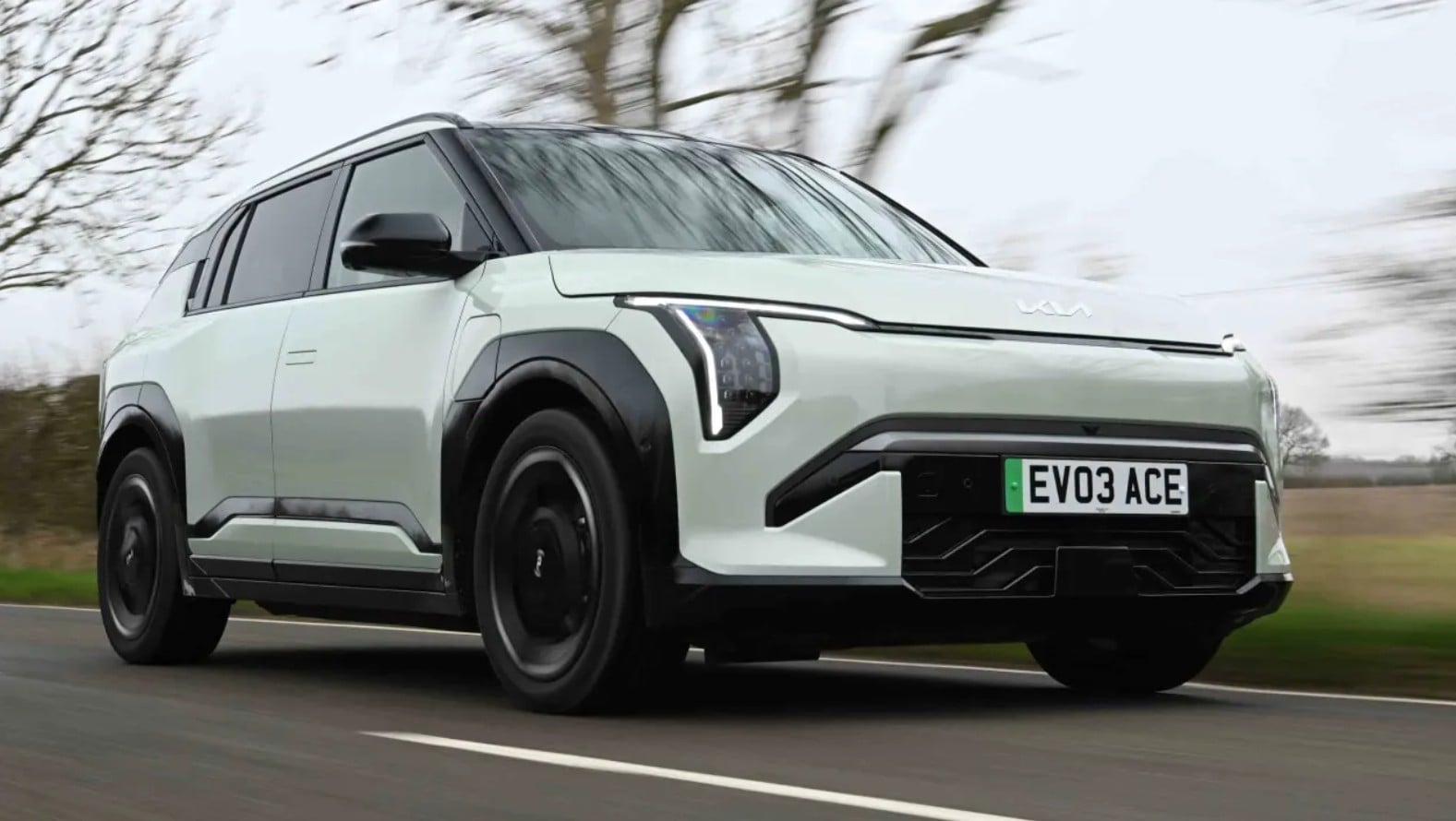 Front three-quarter view of a white modern SUV driving on a road, motion blurred background, plate EVO3 ACE.