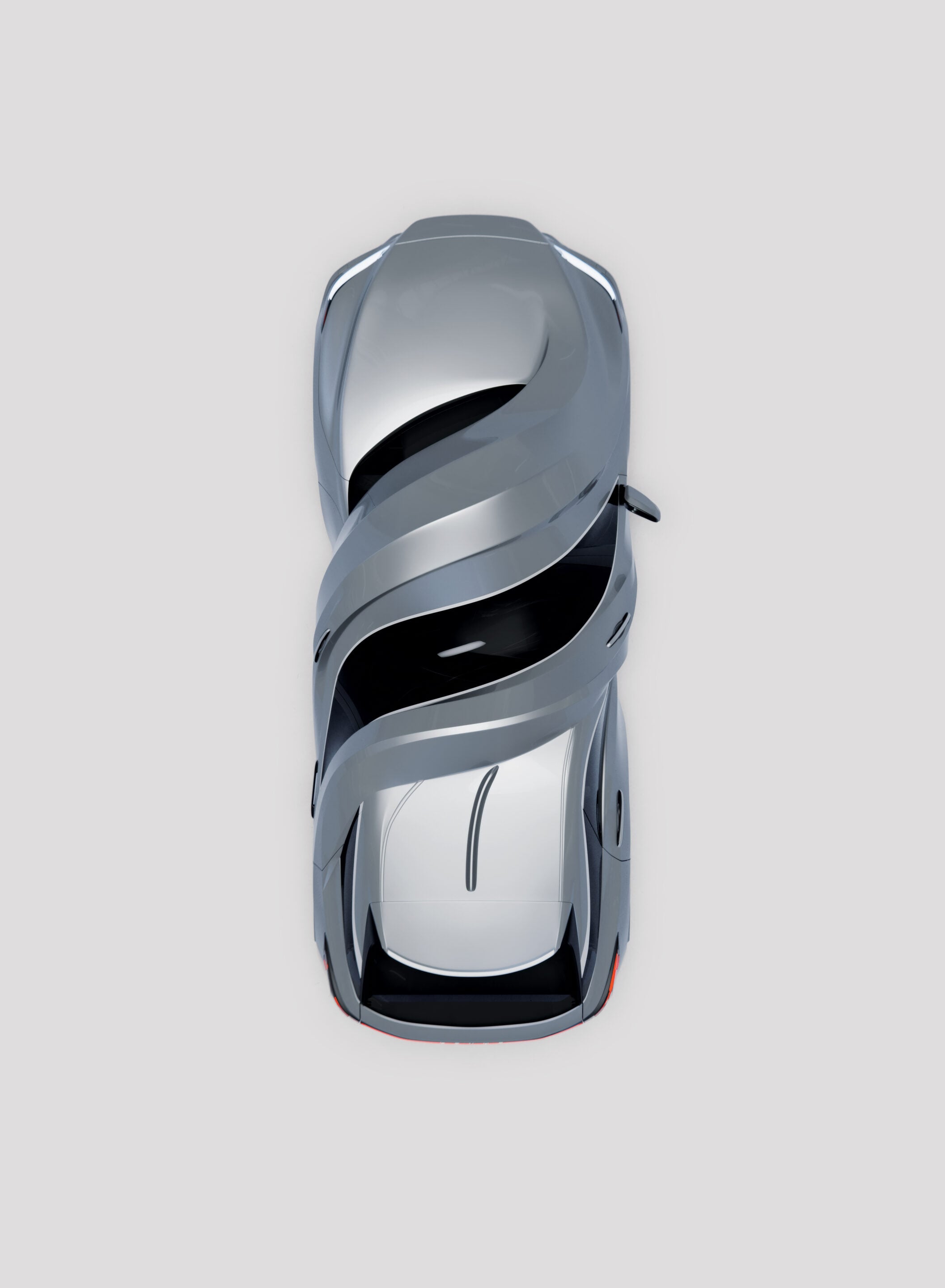 Overhead view of a futuristic silver sports car with swirling metallic ribbons wrapped around its body.