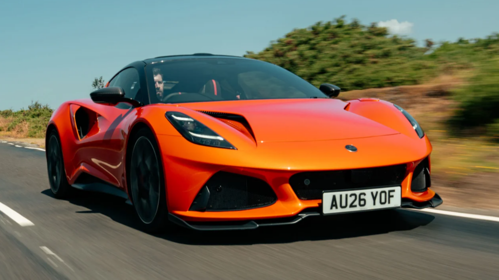 Orange sports car speeding along a rural road, front-right view with motion blur in the background